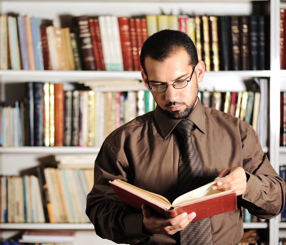 Young man reading book in library